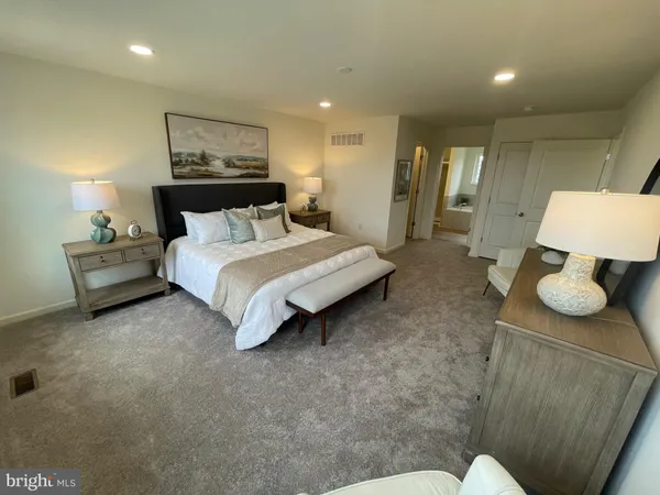 a spacious bedroom with a bed window and couch