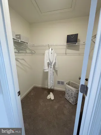 a view of a hallway with closet and bathroom