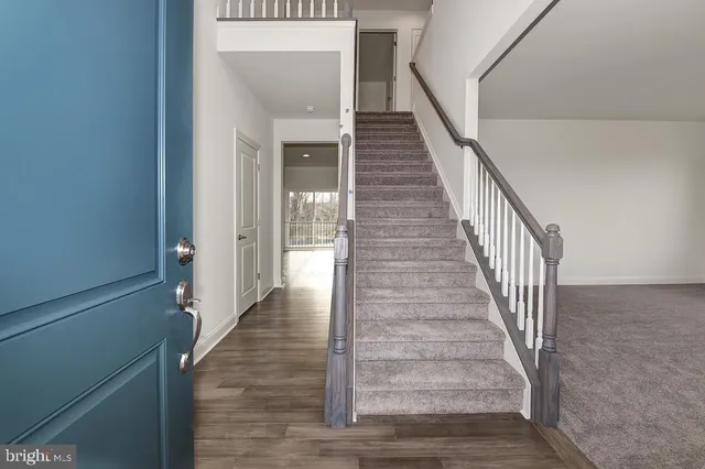 a view of a hallway with wooden floor and staircase