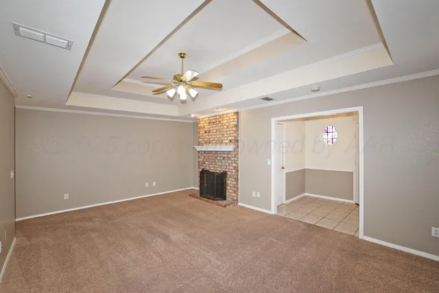 an empty room with windows and chandelier fan