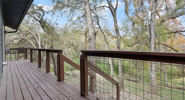 a view of balcony with wooden floor and fence