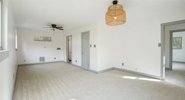 an empty room with a fan and mirror