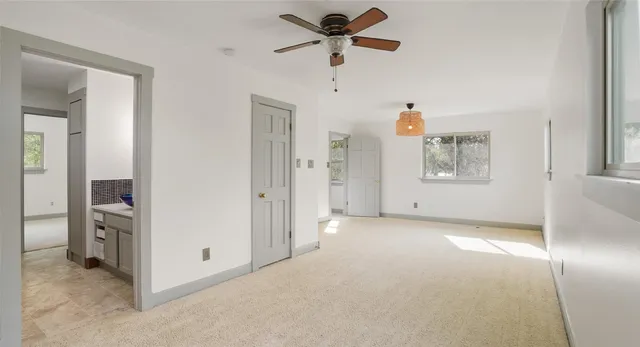 a view of a livingroom with a ceiling fan and window