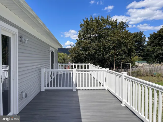 a view of deck with a large window and wooden floor