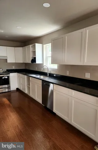 a kitchen with granite countertop a sink and cabinets