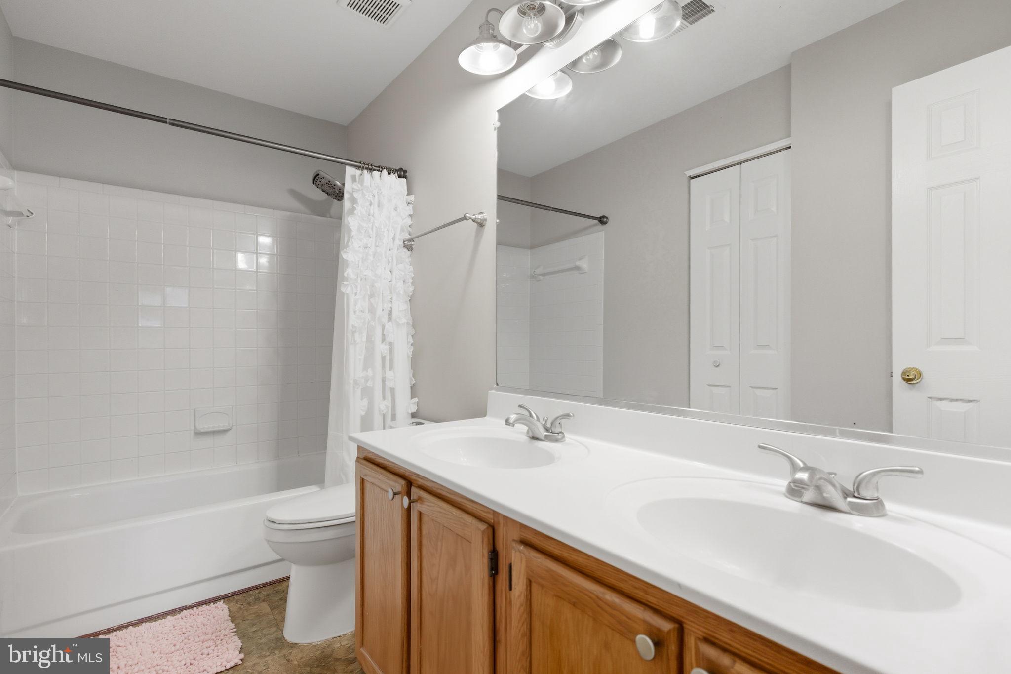 47587 Comer Square Sterling, VA 20165 - Photo 42 of 77 a bathroom with a sink a toilet a mirror a bathtub and shower