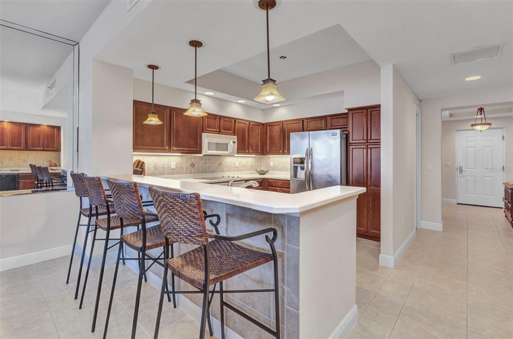 3321 Sunset Key Circle, Unit 502 Punta Gorda, FL 33955 - Photo 11 of 36 a kitchen with stainless steel appliances granite countertop a kitchen island a stove a sink a dining table and chairs