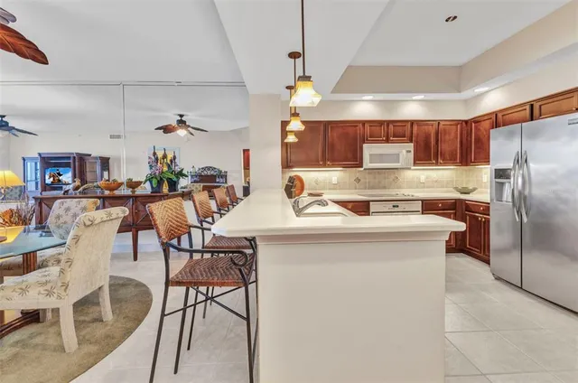 a kitchen with stainless steel appliances granite countertop a kitchen island a stove a sink a dining table and chairs