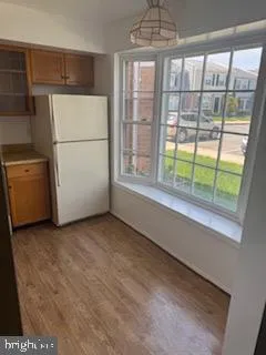 a view of a kitchen with an empty refrigerator and a window