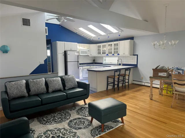 a living room with furniture and a dining table with kitchen view