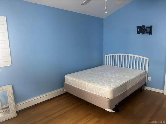 a white bed sitting in a bedroom next to a window