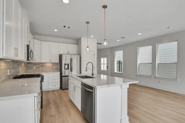 a kitchen with stainless steel appliances granite countertop a sink stove and refrigerator