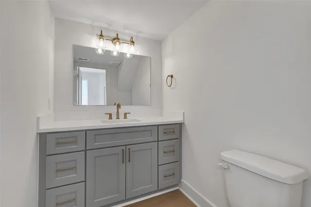 a bathroom with a toilet sink and mirror