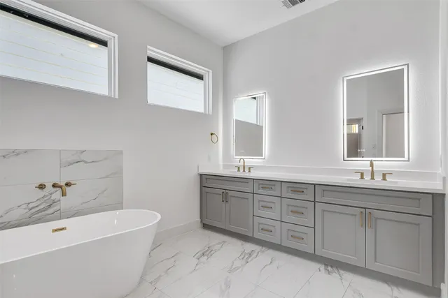 a spacious bathroom with a double vanity sink and a bathtub