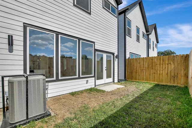 a view of a house with backyard and wooden fence