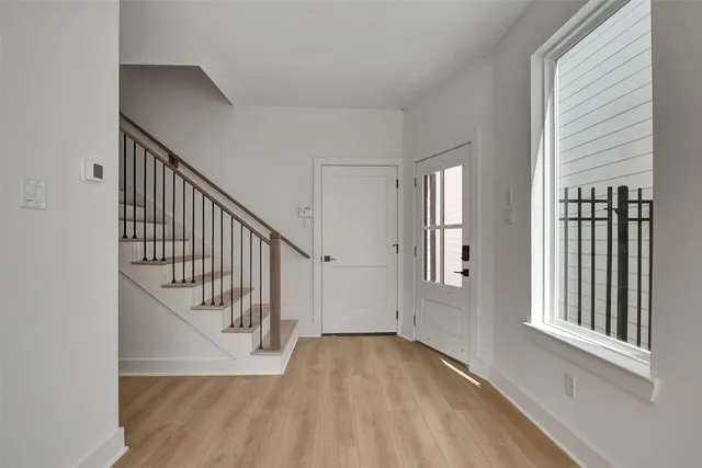 a view of entryway and hall with wooden floor