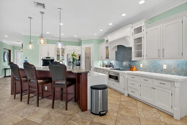 a large kitchen with cabinets table and chairs