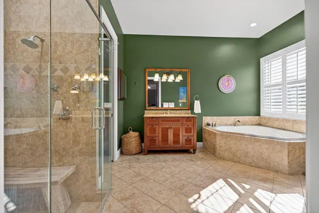 a bathroom with a tub a sink and a large mirror