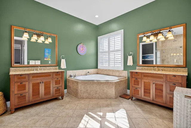 a spacious bathroom with a granite countertop tub sink and mirror
