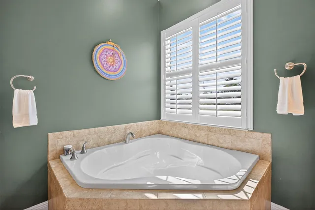 a bath tub sitting in a bathroom next to a window