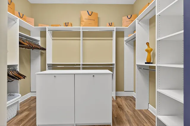 a view of walk in closet with clothes and shoes