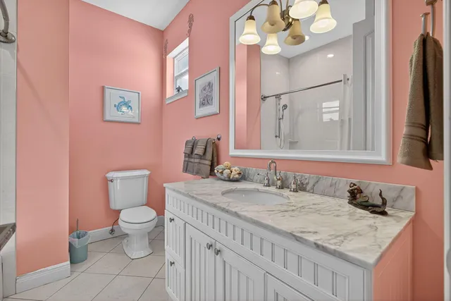 a bathroom with a granite countertop toilet sink and mirror