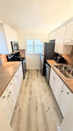 a kitchen with a sink stove and refrigerator