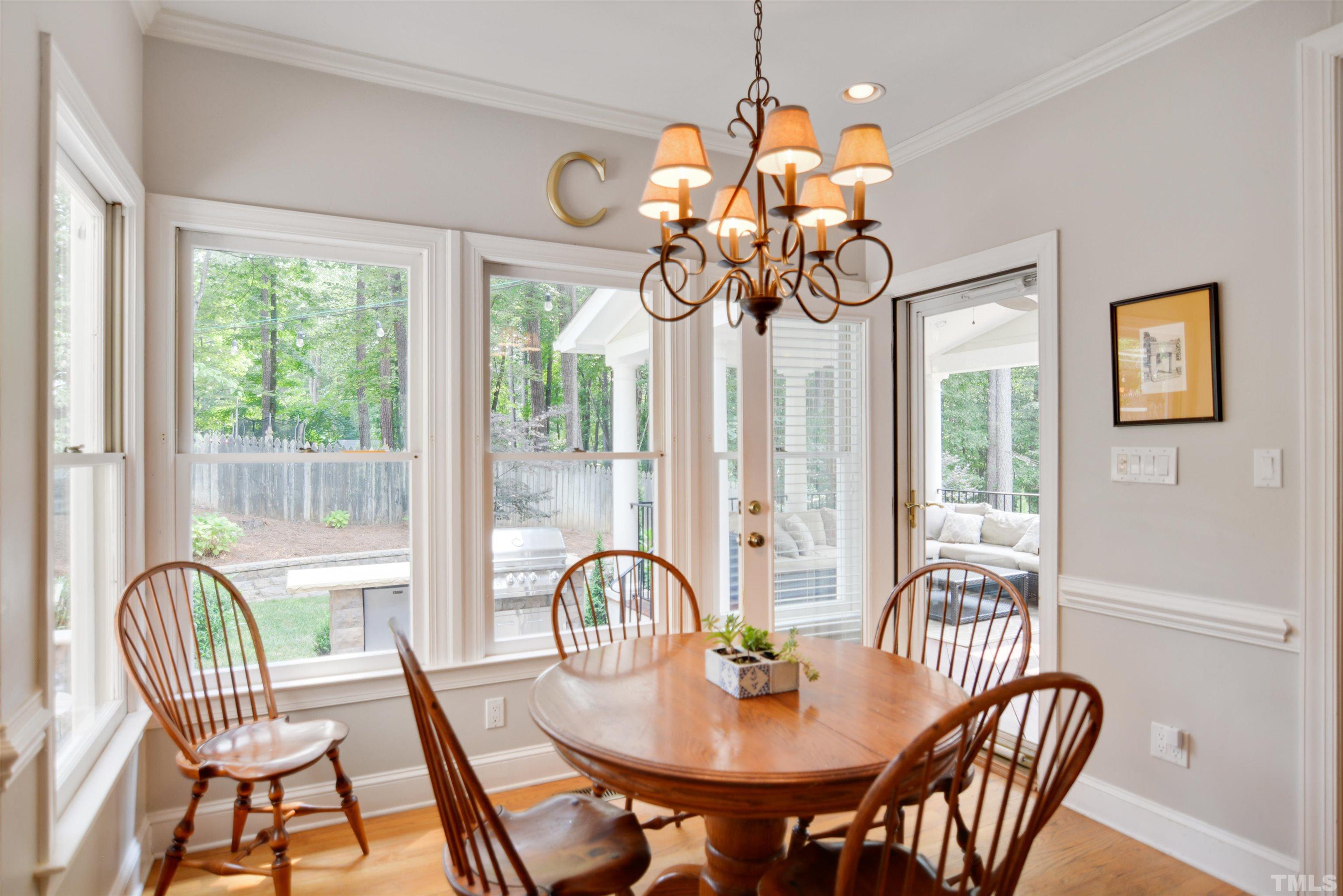 3005 Dunkirk Drive Raleigh, NC 27613 - Photo 12 of 35 a dining room with wooden floor a chandelier a livingroom and chairs