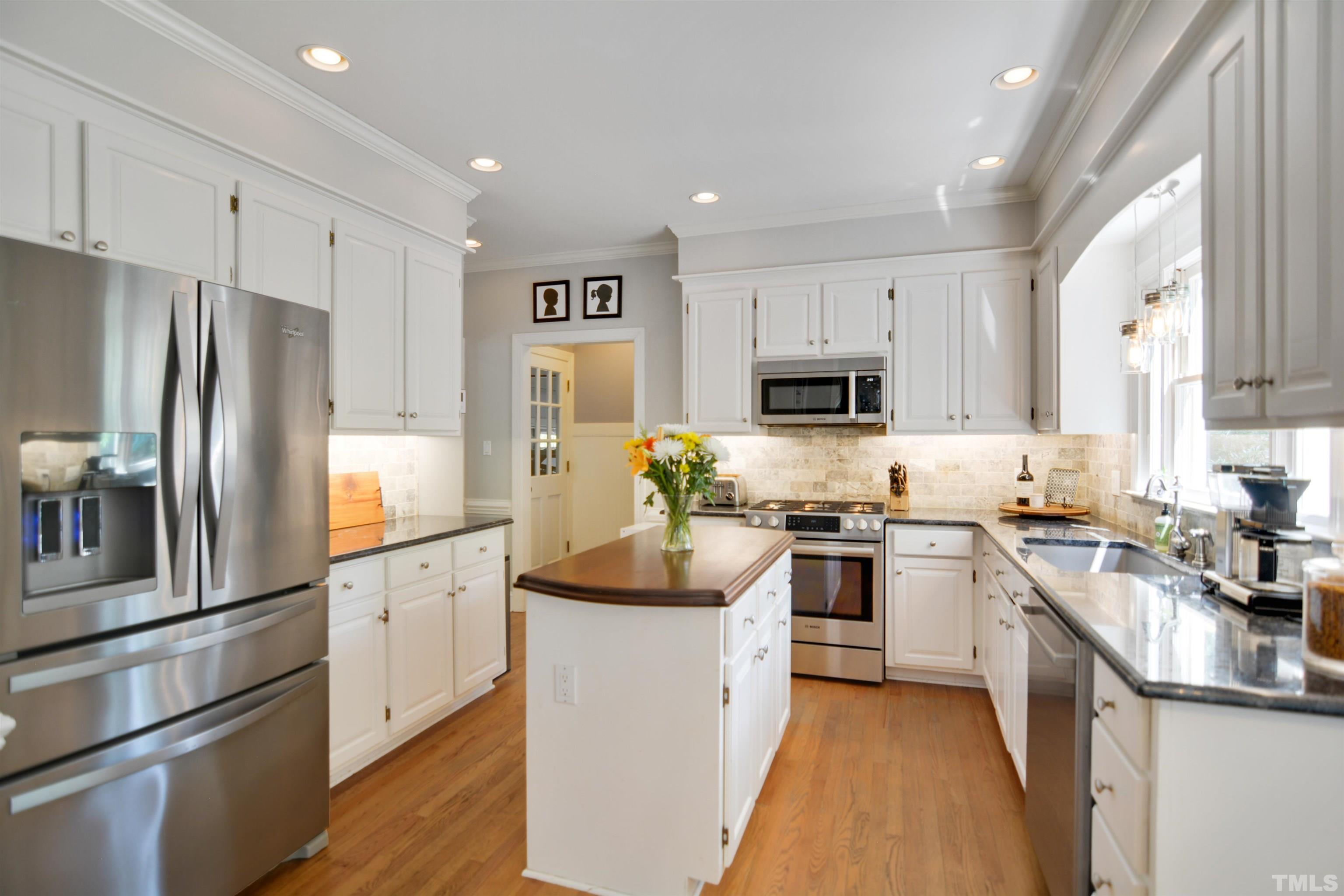 3005 Dunkirk Drive Raleigh, NC 27613 - Photo 9 of 35 a kitchen with white cabinets and stainless steel appliances