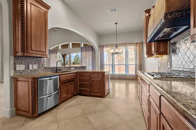 a kitchen with stainless steel appliances granite countertop a stove a sink and a refrigerator