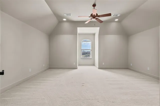 an empty room with closet and a ceiling fan