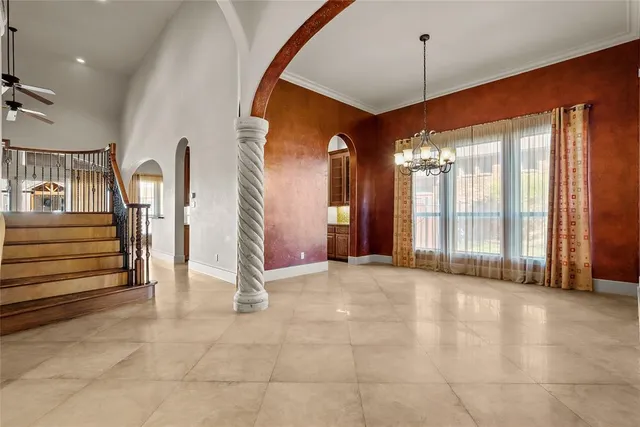 a view of an empty room with stairs and furniture