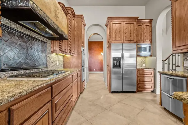 a kitchen with stainless steel appliances granite countertop a stove a refrigerator and a oven