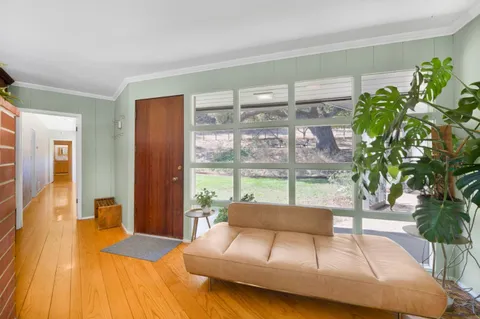 a bedroom with a bed and a large window with outer view