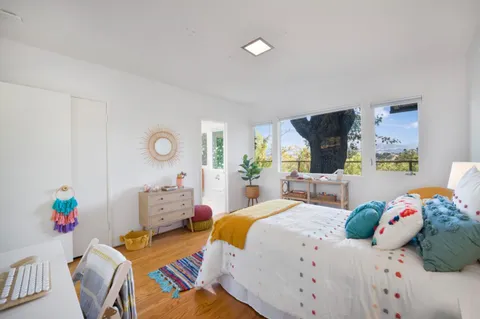 a bedroom with two beds and a dresser with mirror