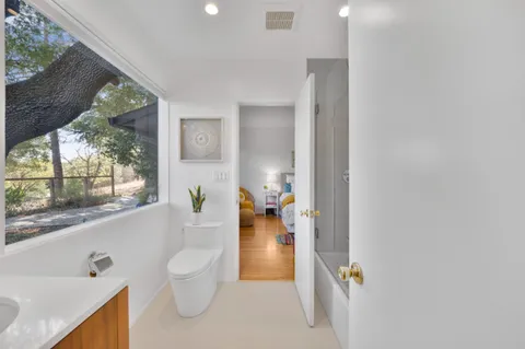 a bathroom with a tub sink and mirror
