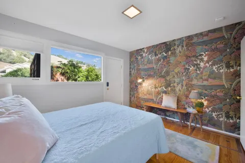 a bedroom with a large window and a bed