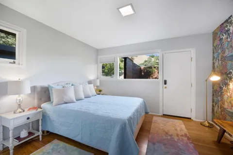 a bedroom with a bed and a flat tv screen on dresser