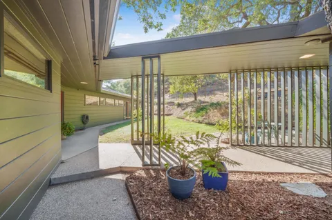 a view of a balcony with chairs and a potted plant