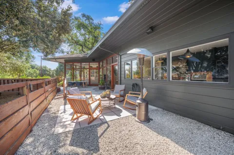 a view of a house with backyard wooden floor and outdoor seating