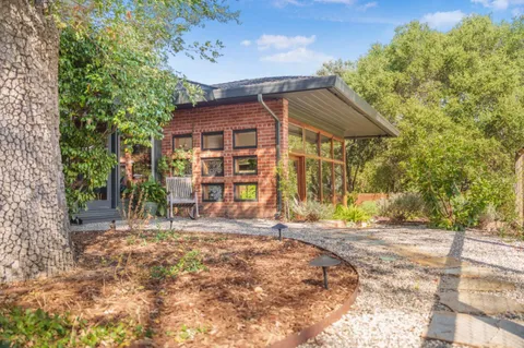 a view of a house with backyard and trees