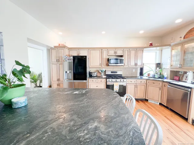 a large white kitchen with stainless steel appliances lots of counter space and a sink
