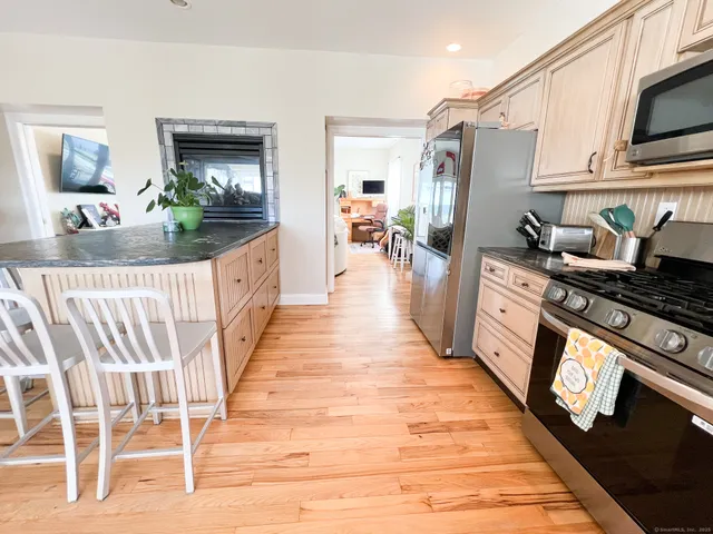 a open kitchen with stainless steel appliances granite countertop a stove top oven and a refrigerator