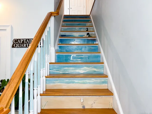 a spacious bedroom with a bed and a potted plant on the dresser