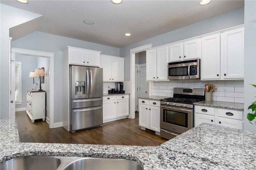 225 Nut Hatch Loop Arden, NC 28704 - Photo 12 of 48 a kitchen with granite countertop a refrigerator stove and microwave