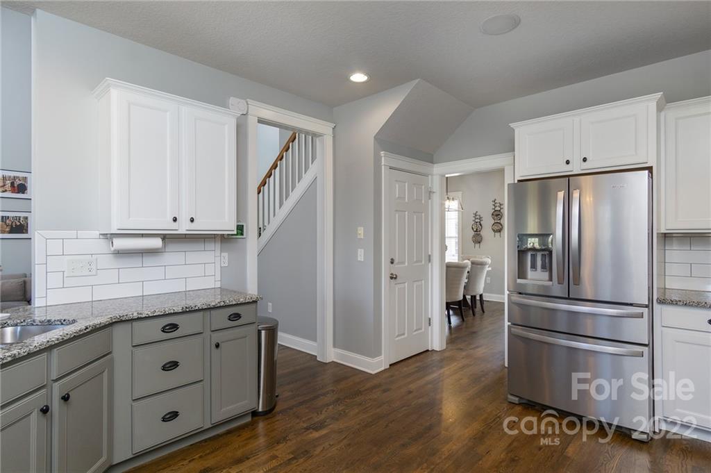 225 Nut Hatch Loop Arden, NC 28704 - Photo 14 of 48 a kitchen with granite countertop stainless steel appliances a refrigerator and cabinets