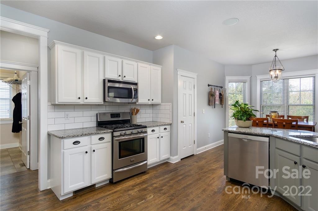 225 Nut Hatch Loop Arden, NC 28704 - Photo 15 of 48 a kitchen with stainless steel appliances granite countertop a stove a sink and a microwave