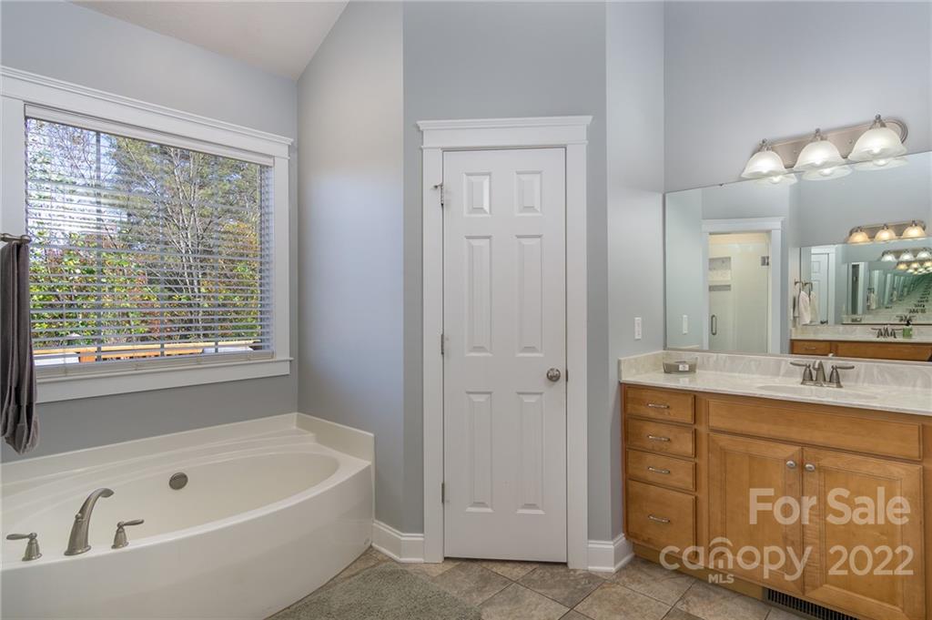 225 Nut Hatch Loop Arden, NC 28704 - Photo 20 of 48 a bathroom with a tub a sink and a window