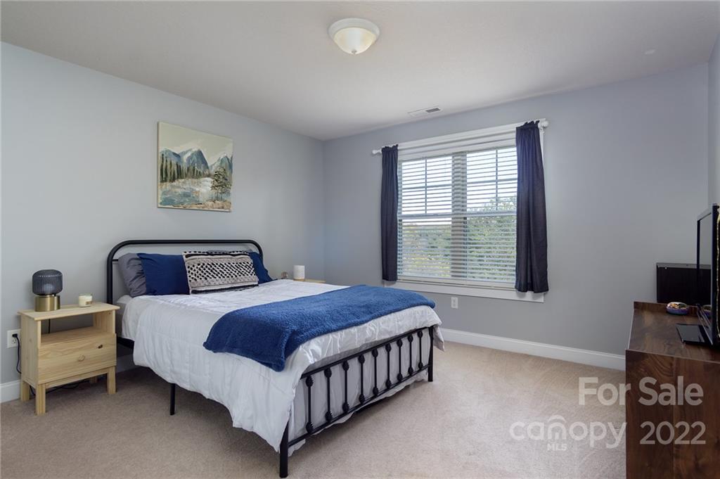225 Nut Hatch Loop Arden, NC 28704 - Photo 26 of 48 a bedroom with a bed and a tv on the dresser