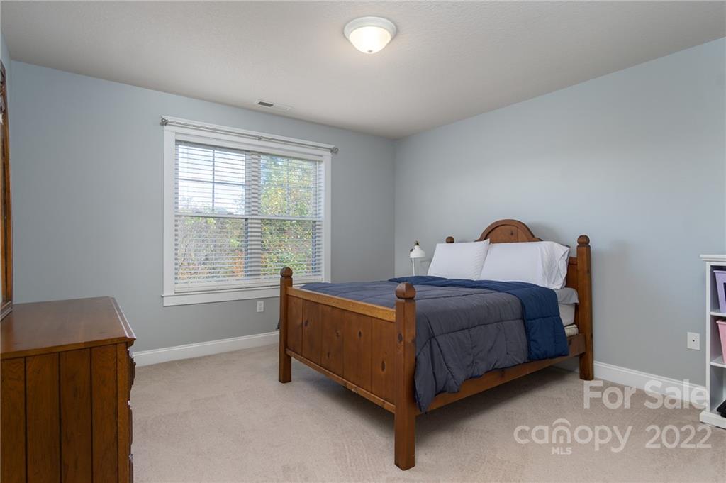 225 Nut Hatch Loop Arden, NC 28704 - Photo 27 of 48 a bed sitting in a bedroom next to a window